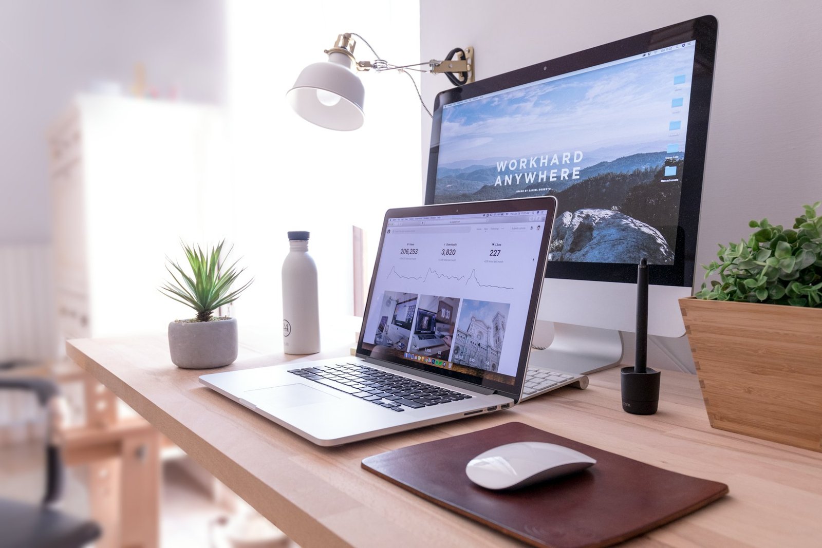 Bright workspace with laptop, monitor and plants